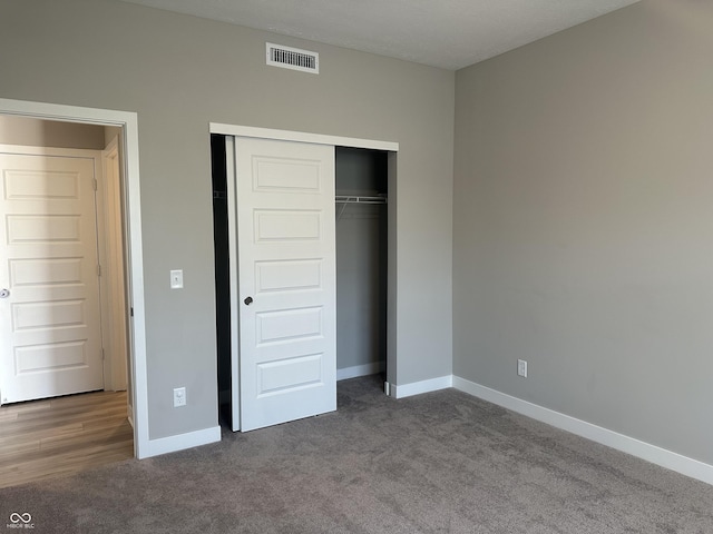 unfurnished bedroom featuring carpet flooring and a closet