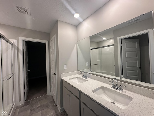 bathroom featuring vanity and a shower with door