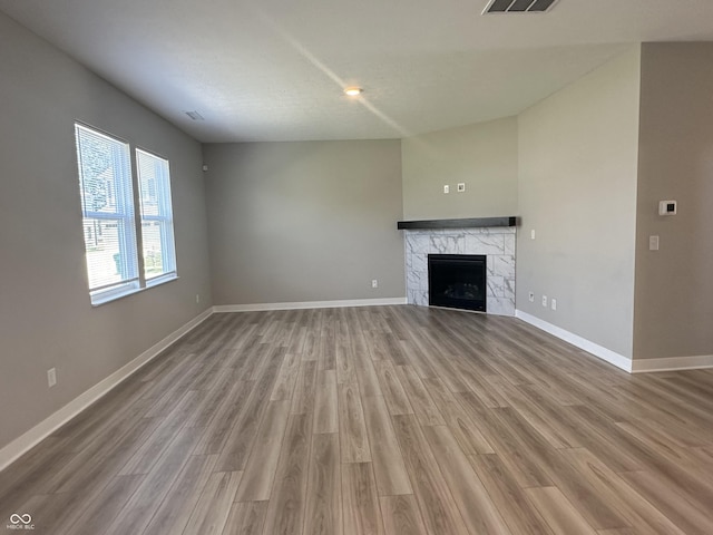 unfurnished living room featuring hardwood / wood-style floors and a tile fireplace