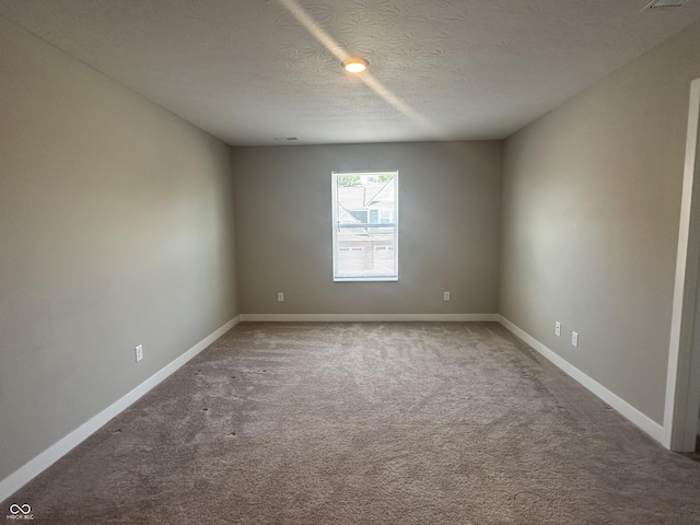 carpeted spare room featuring a textured ceiling