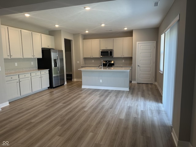 kitchen with white cabinetry, appliances with stainless steel finishes, sink, and light hardwood / wood-style flooring