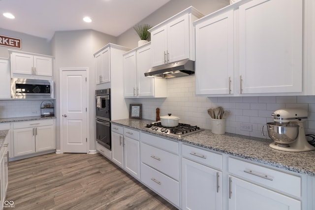 kitchen with white cabinets, under cabinet range hood, and appliances with stainless steel finishes