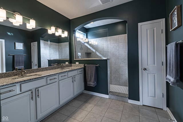 full bathroom with a sink, tile patterned floors, walk in shower, and double vanity