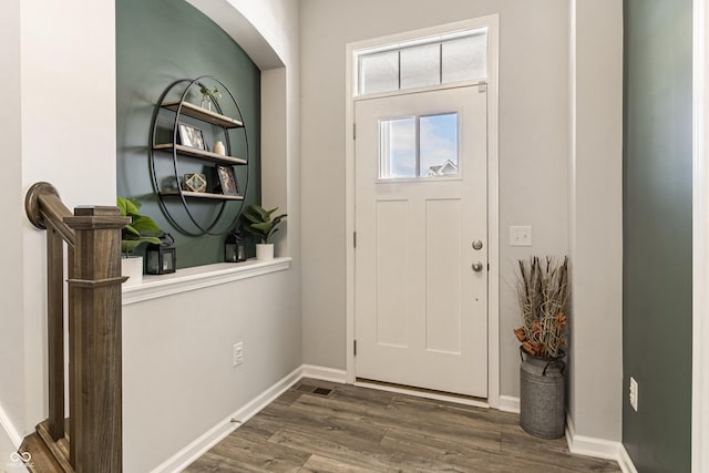 foyer entrance with dark wood finished floors and baseboards