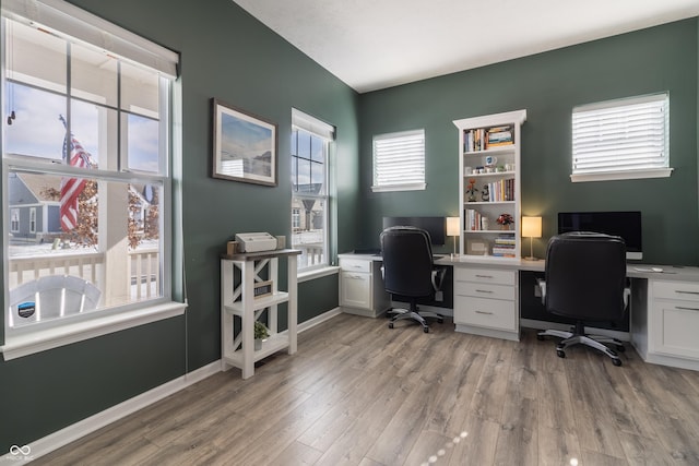 office space with baseboards and light wood-style floors