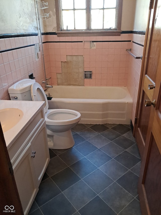 full bathroom with tile patterned floors, toilet, tile walls, and vanity