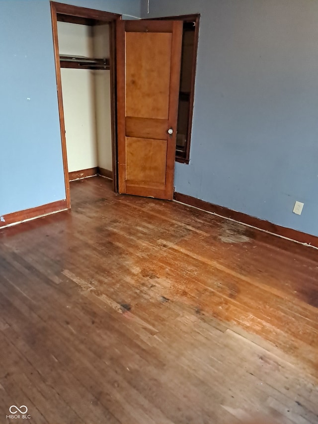 unfurnished bedroom featuring dark hardwood / wood-style floors and a closet