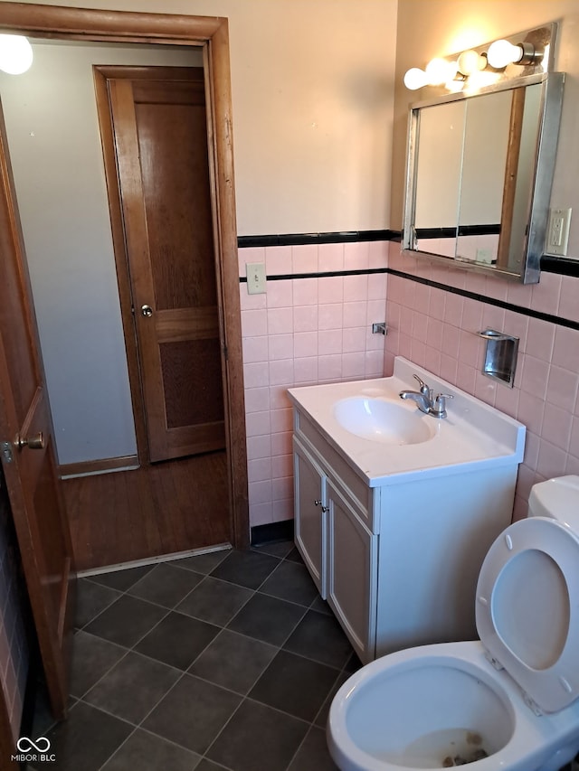 bathroom with tile patterned flooring, vanity, tile walls, and toilet