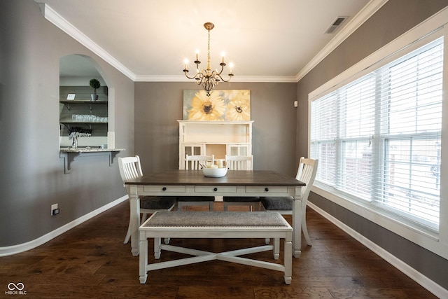 dining area featuring an inviting chandelier, crown molding, and dark hardwood / wood-style floors