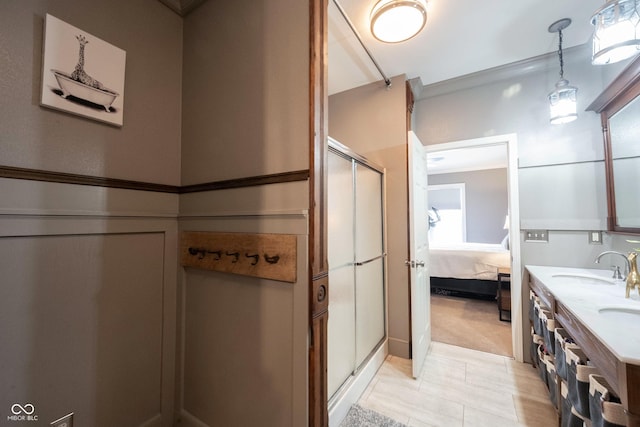 bathroom with vanity, crown molding, and a shower with shower door