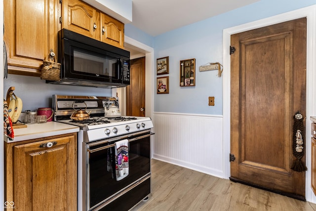 kitchen featuring range with gas stovetop and light hardwood / wood-style flooring