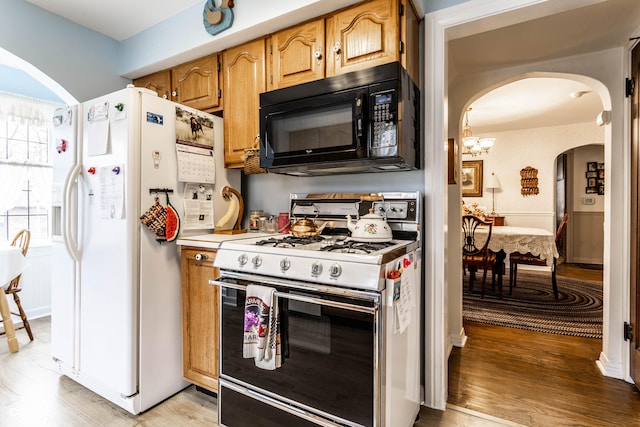 kitchen featuring white appliances and light hardwood / wood-style flooring