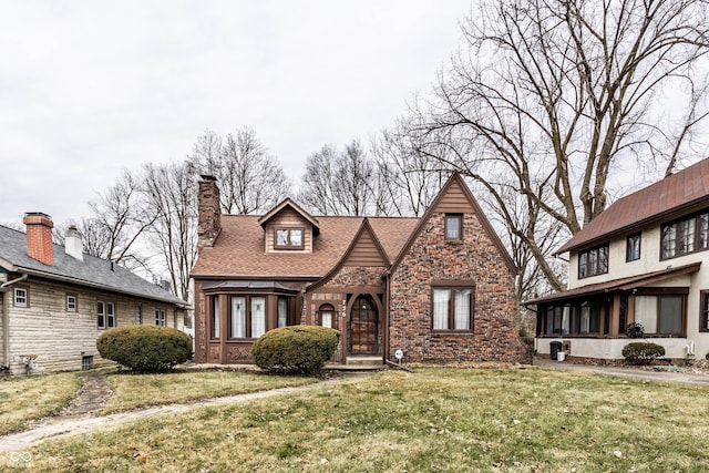 english style home featuring a front yard