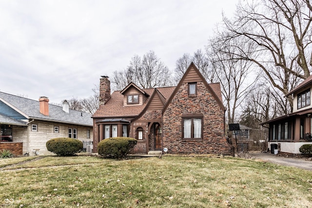 english style home with a front lawn