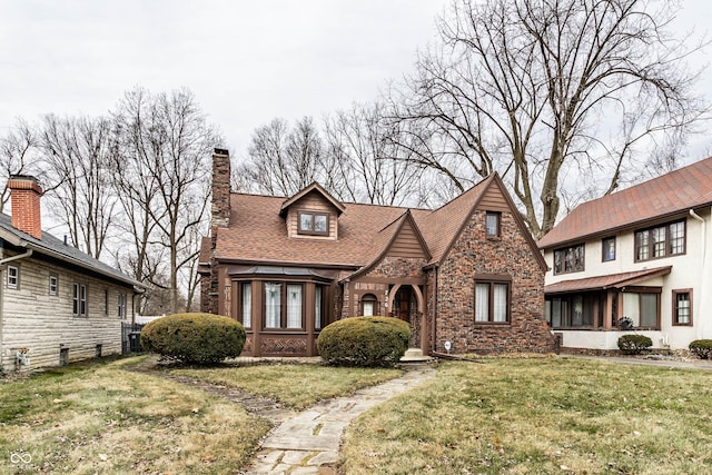 tudor home with a front lawn