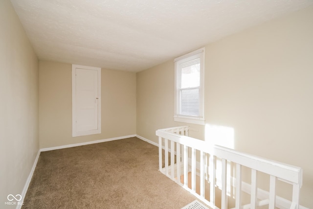 carpeted spare room featuring a textured ceiling