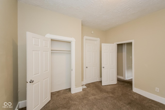 unfurnished bedroom featuring a closet, dark carpet, and a textured ceiling