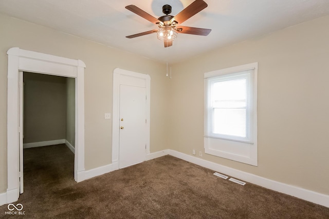 carpeted spare room featuring ceiling fan