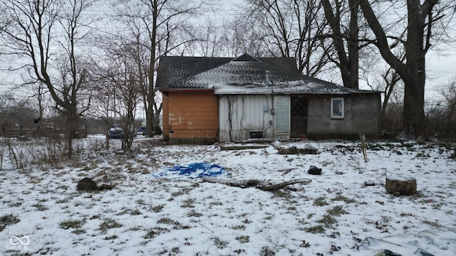 view of snow covered back of property