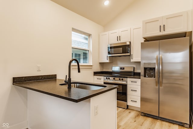 kitchen featuring white cabinetry, lofted ceiling, sink, kitchen peninsula, and stainless steel appliances