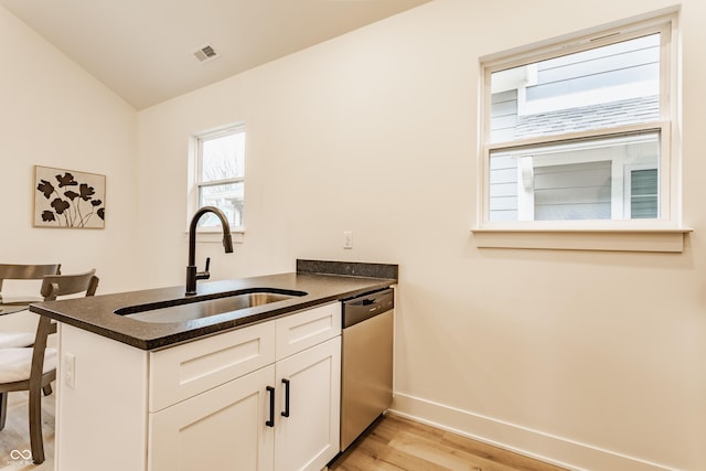 kitchen with sink, white cabinetry, dishwasher, kitchen peninsula, and light hardwood / wood-style floors