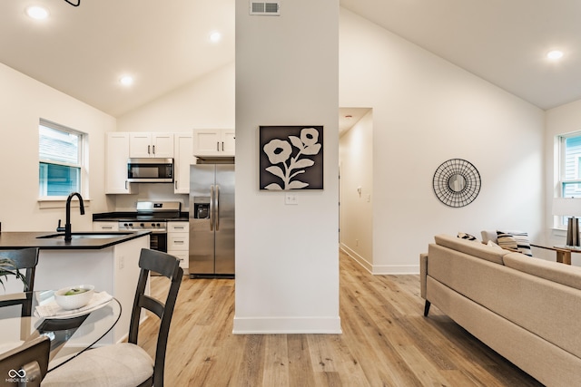 kitchen with white cabinetry, stainless steel appliances, sink, and light wood-type flooring