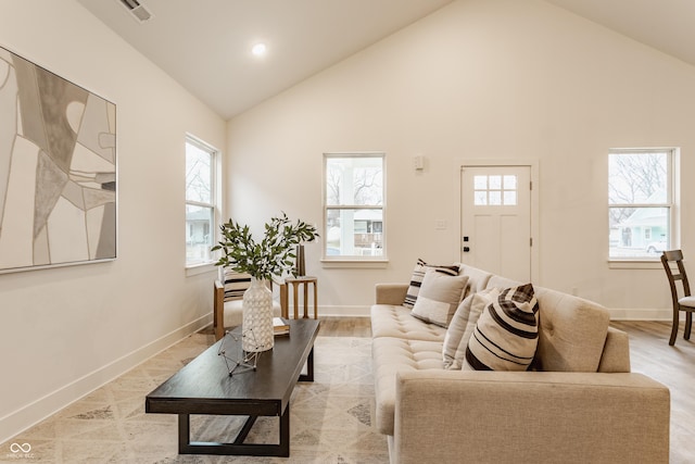 living room with light wood-type flooring and high vaulted ceiling