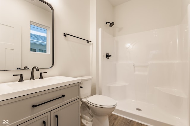 bathroom featuring walk in shower, hardwood / wood-style floors, vanity, and toilet