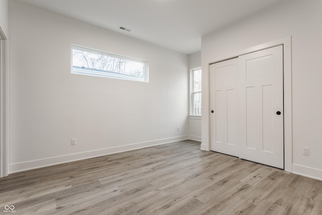 unfurnished bedroom featuring light wood-type flooring and a closet