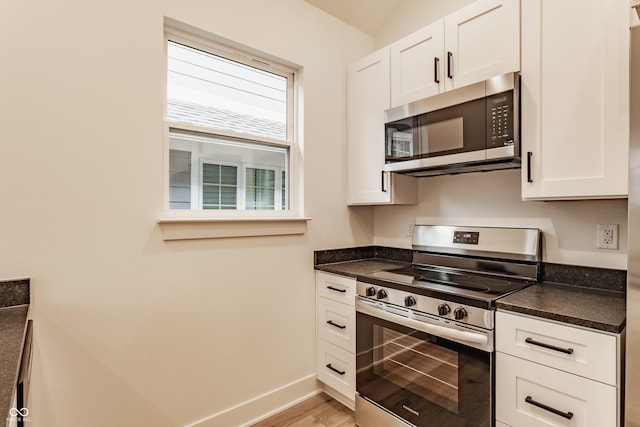 kitchen featuring appliances with stainless steel finishes, light hardwood / wood-style floors, and white cabinets