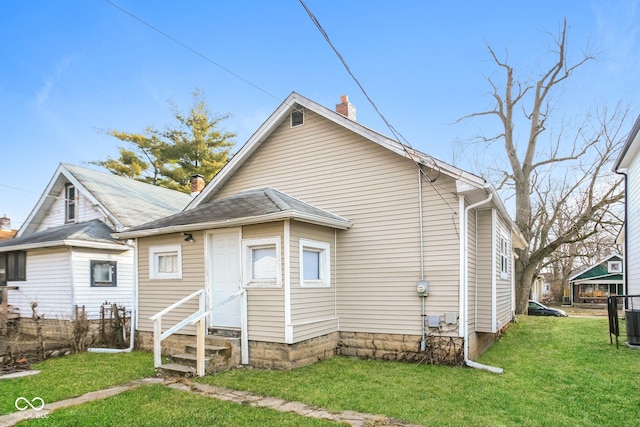 rear view of property with a yard