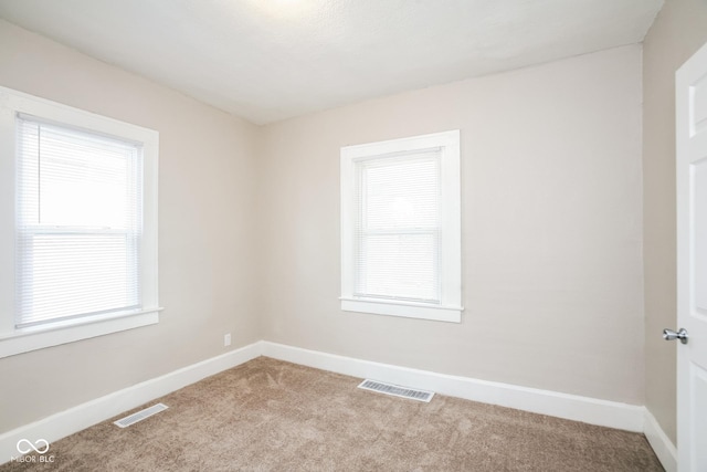 carpeted spare room featuring a healthy amount of sunlight