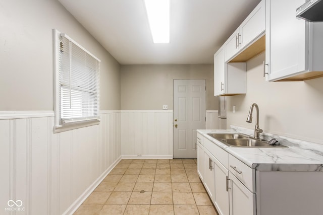 kitchen featuring white cabinetry, light tile patterned floors, sink, and exhaust hood