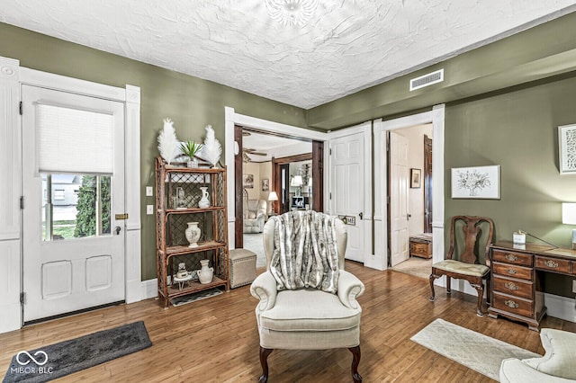 living area featuring hardwood / wood-style flooring and a textured ceiling