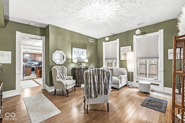 living area featuring hardwood / wood-style flooring and a textured ceiling