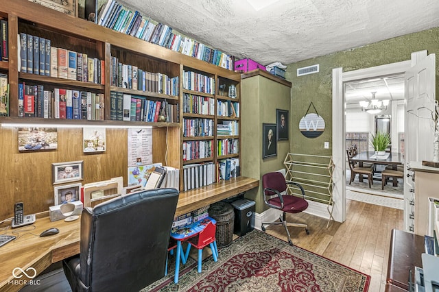 home office featuring a notable chandelier and hardwood / wood-style flooring