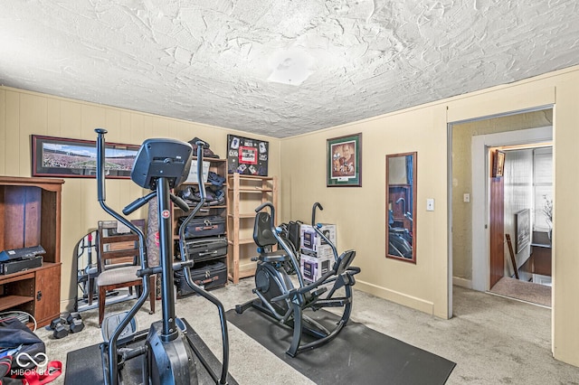 exercise room with light carpet and a textured ceiling