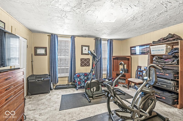 workout area with light colored carpet and a textured ceiling