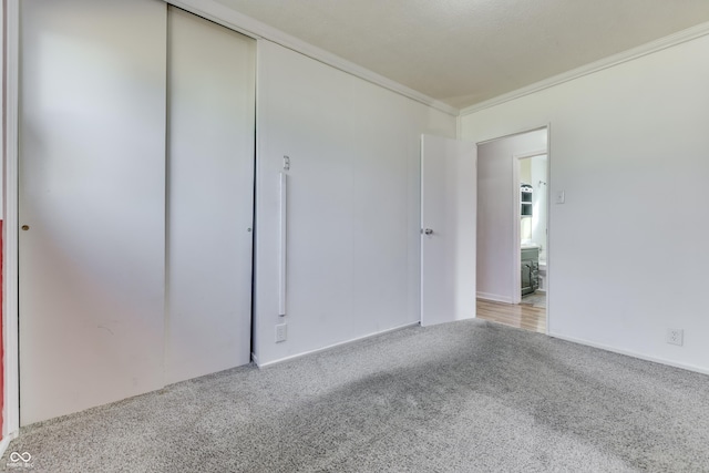 unfurnished room with crown molding and light colored carpet