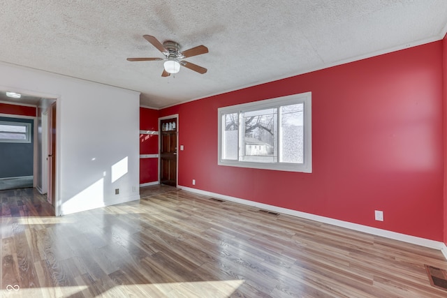 interior space featuring ceiling fan, a spacious closet, light hardwood / wood-style flooring, and a textured ceiling