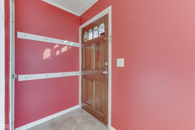 entryway with a textured ceiling and light tile patterned floors