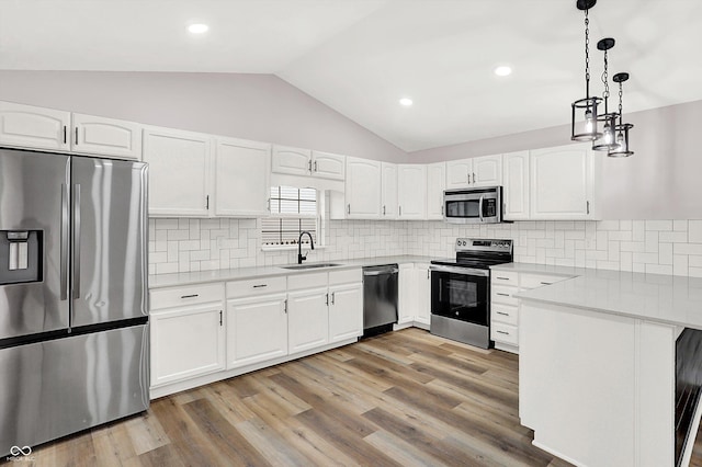 kitchen with sink, stainless steel appliances, hanging light fixtures, and white cabinets