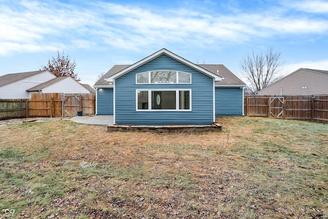 back of property with a yard and a patio