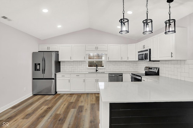 kitchen featuring white cabinetry, appliances with stainless steel finishes, pendant lighting, and kitchen peninsula