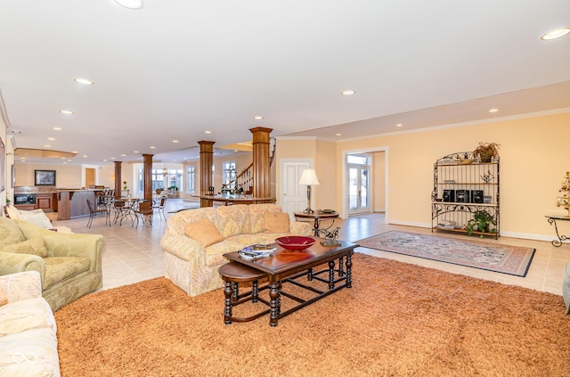 living room with light tile patterned floors, crown molding, a wealth of natural light, and decorative columns