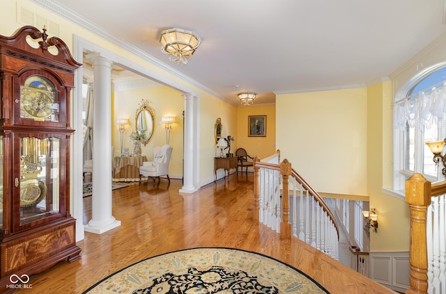 foyer with ornamental molding, decorative columns, and light hardwood / wood-style floors