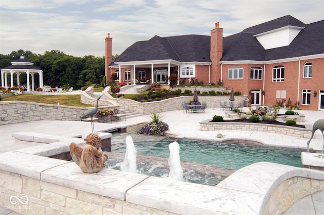 view of swimming pool with a gazebo, pool water feature, and a patio