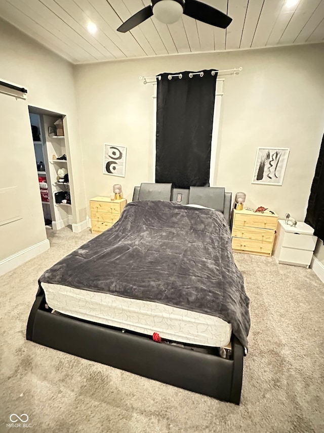 carpeted bedroom with wooden ceiling, a barn door, and ceiling fan