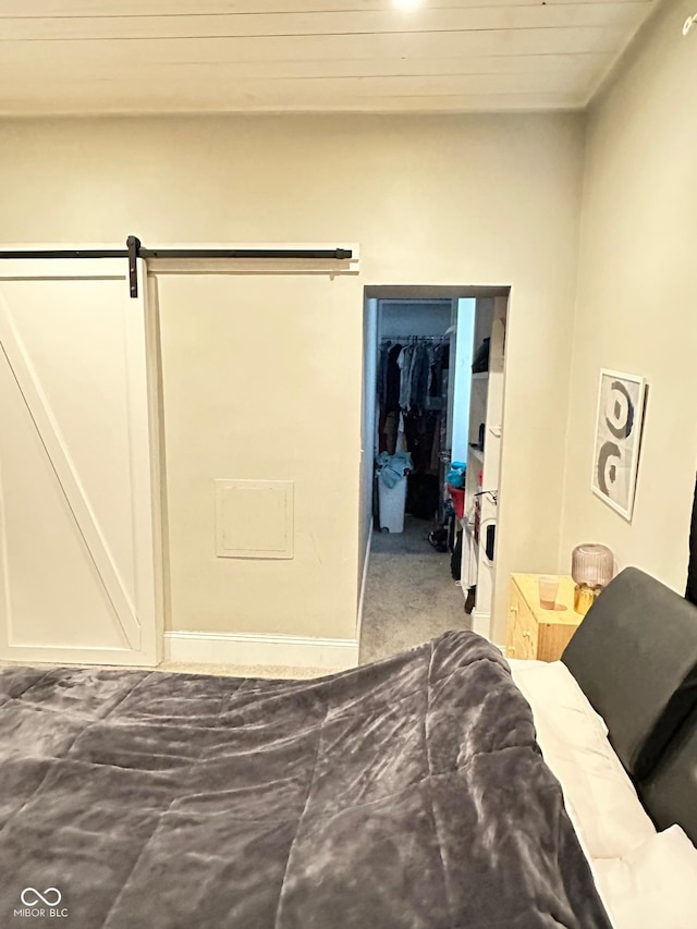 bedroom featuring a walk in closet, a closet, and a barn door