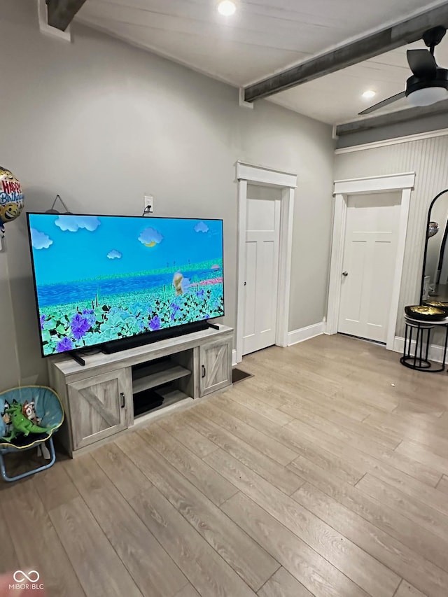 living room with beamed ceiling, ceiling fan, and light hardwood / wood-style flooring